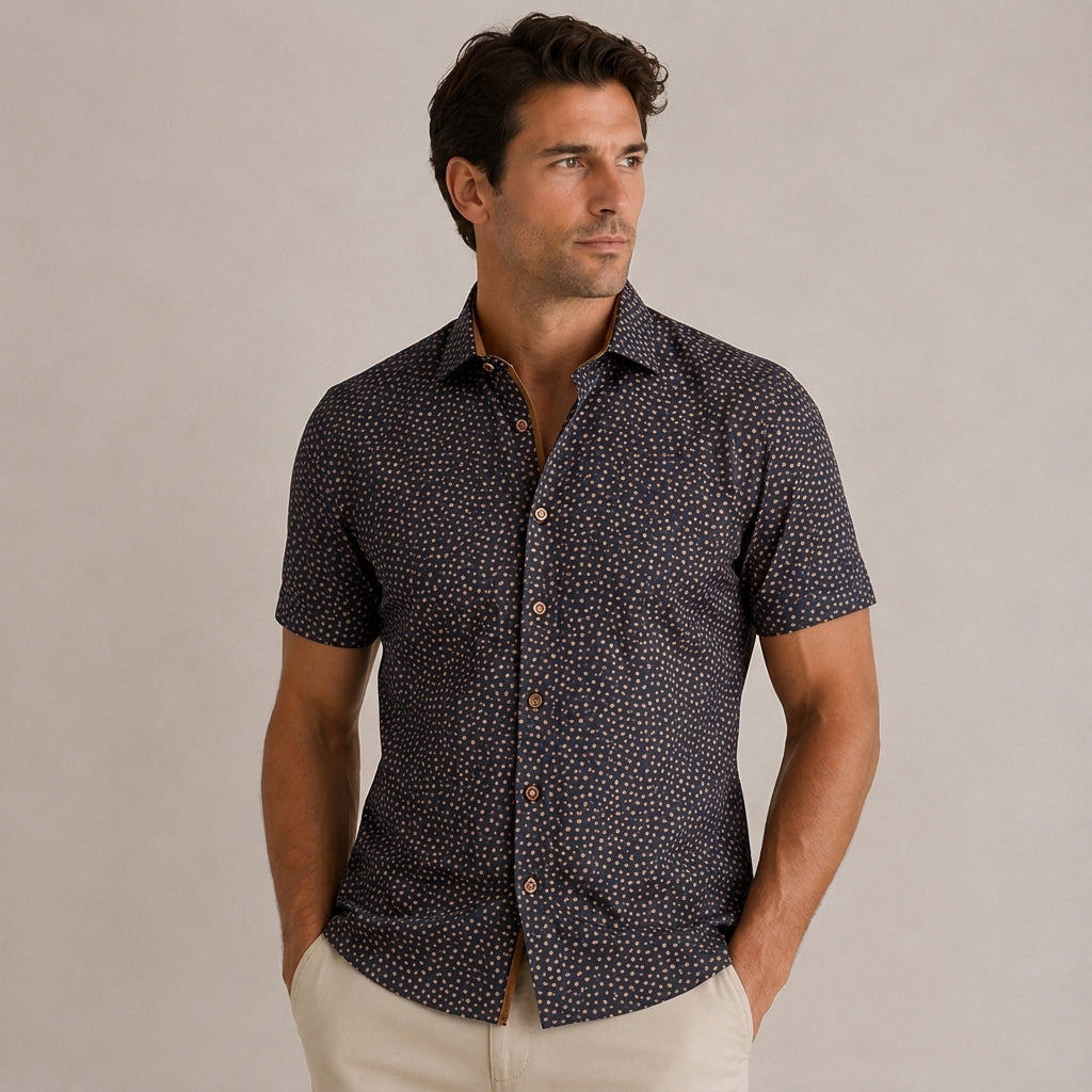 Man wearing a dark patterned short-sleeve shirt against a beige background
