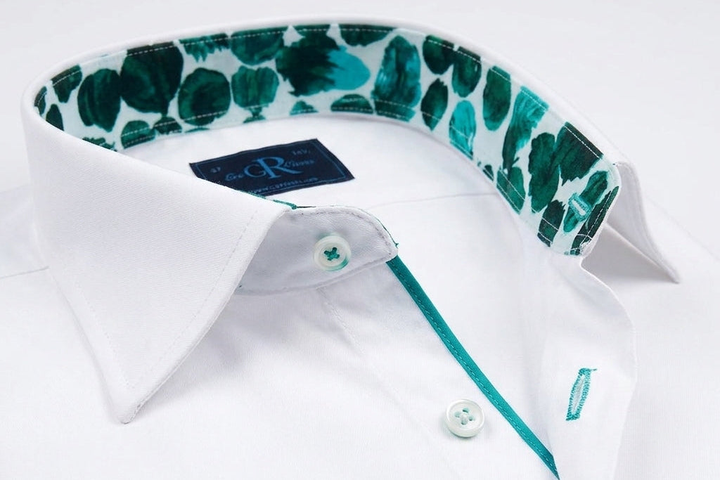 White dress shirt with green patterned collar and trim on a white background