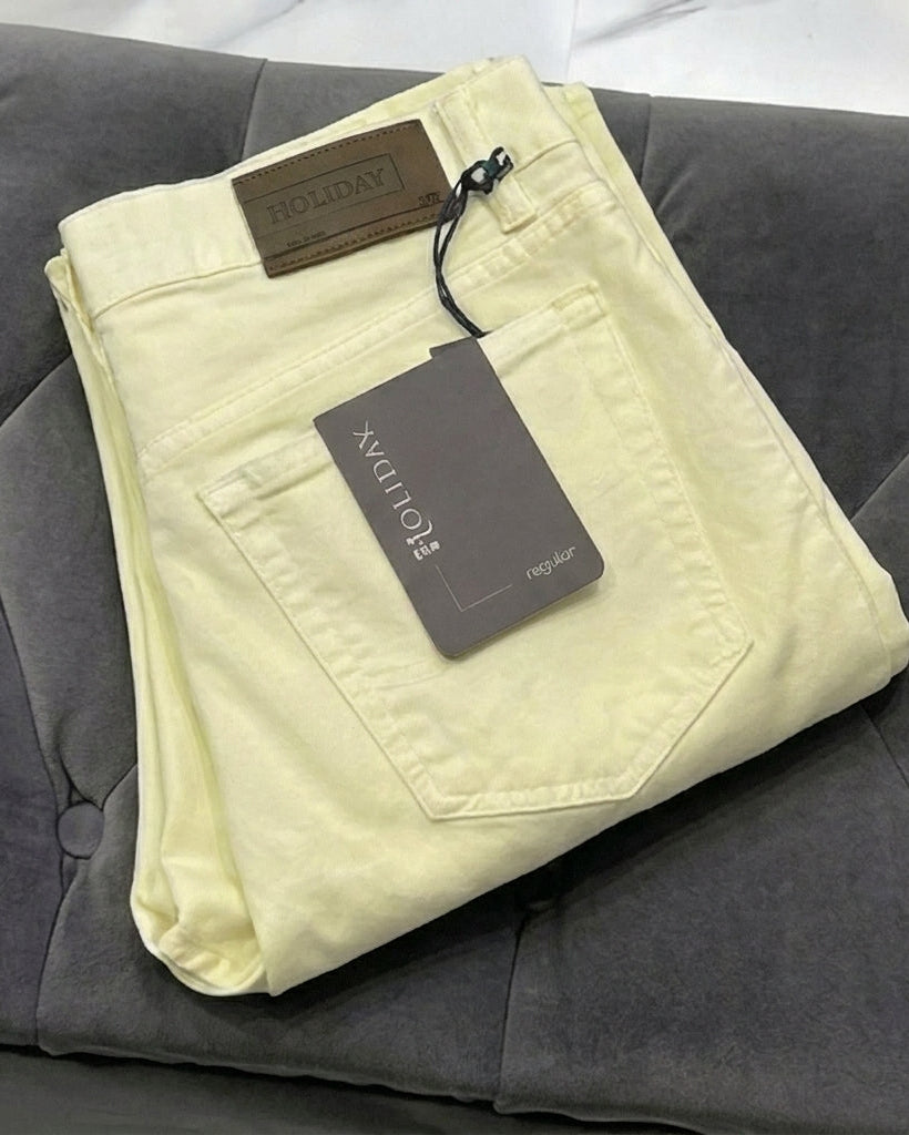 Folded light-colored pants with a tag on a gray surface