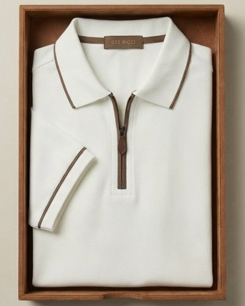 Folded white polo shirt with brown accents in a wooden box on a beige background