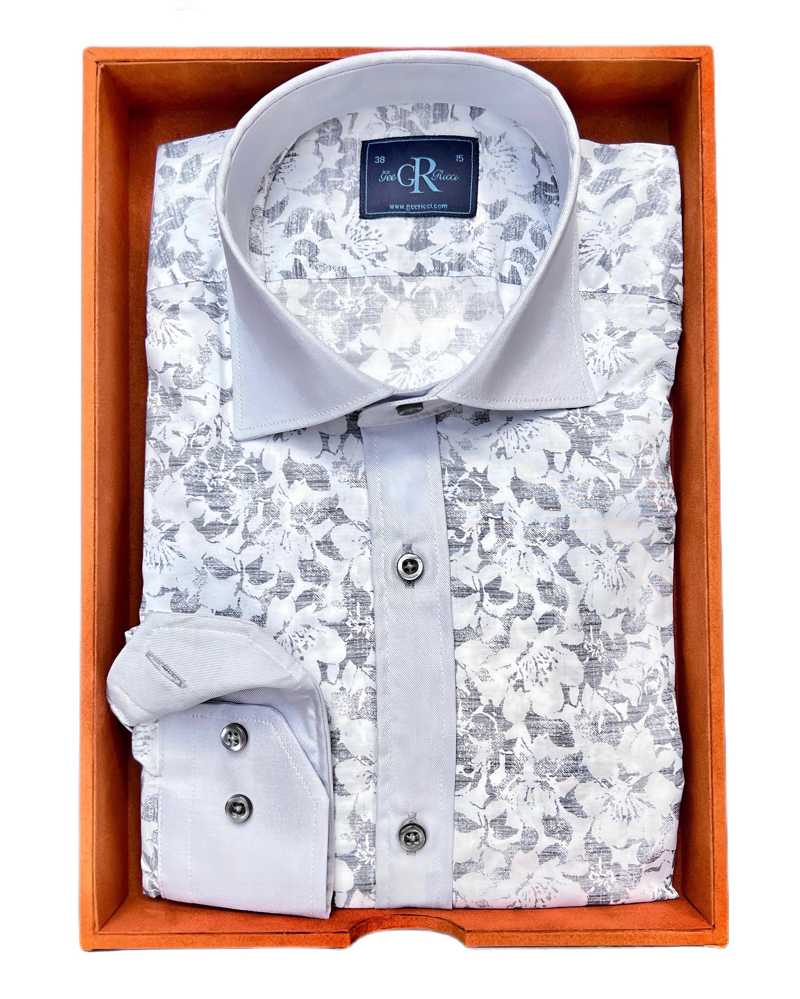 A folded grey oxford cotton shirt with floral pattern on the collar and cuffs, presented in an orange-colored box.