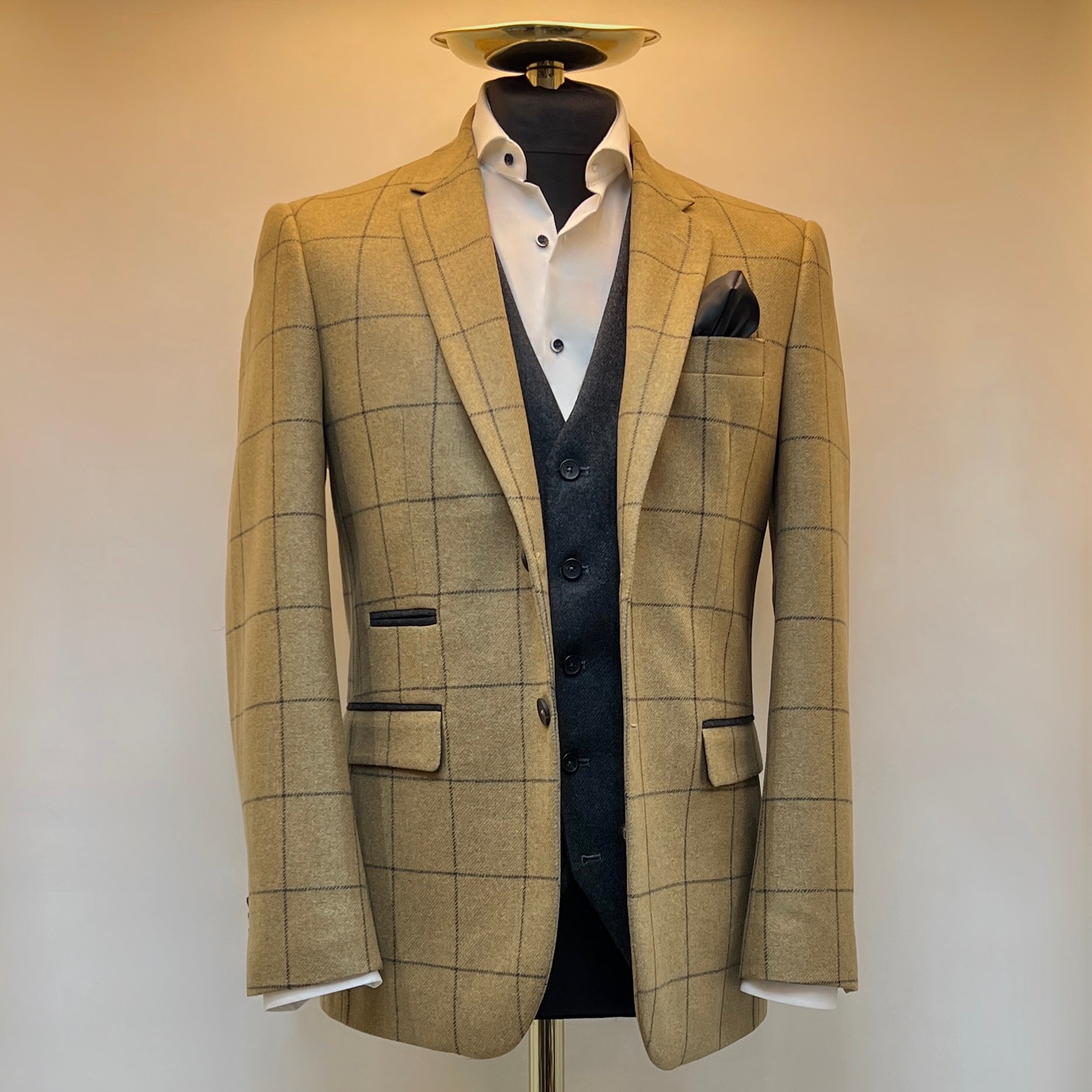 Checkered suit jacket on a mannequin against a plain background