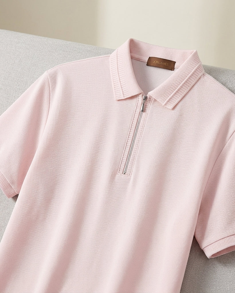 Pink polo shirt with a brand label on a light gray surface
