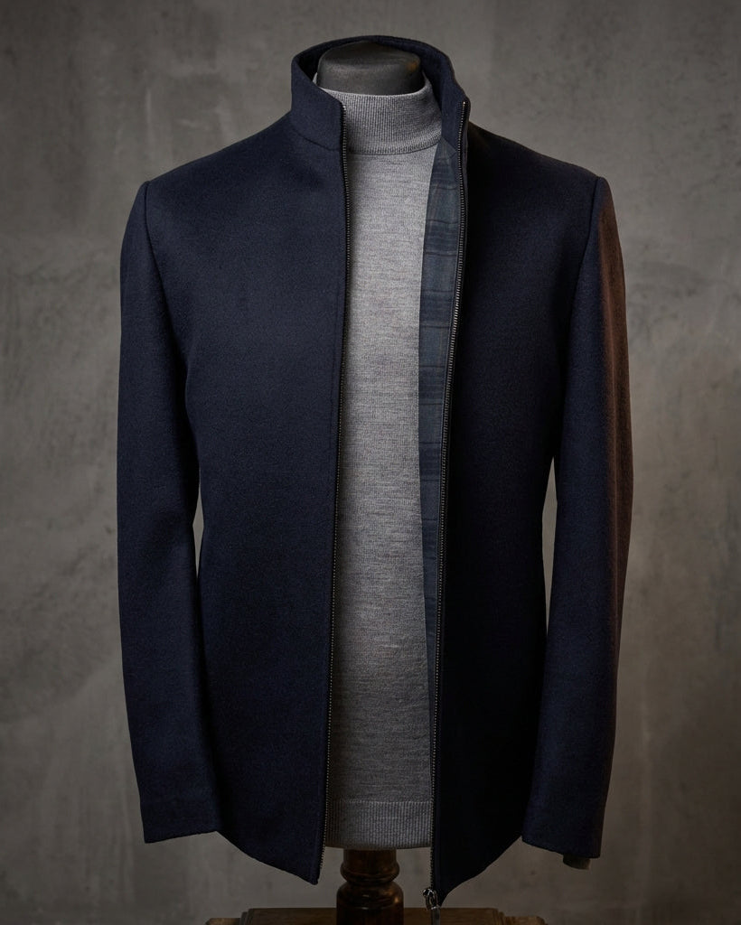 Navy coat on a mannequin against a gray background