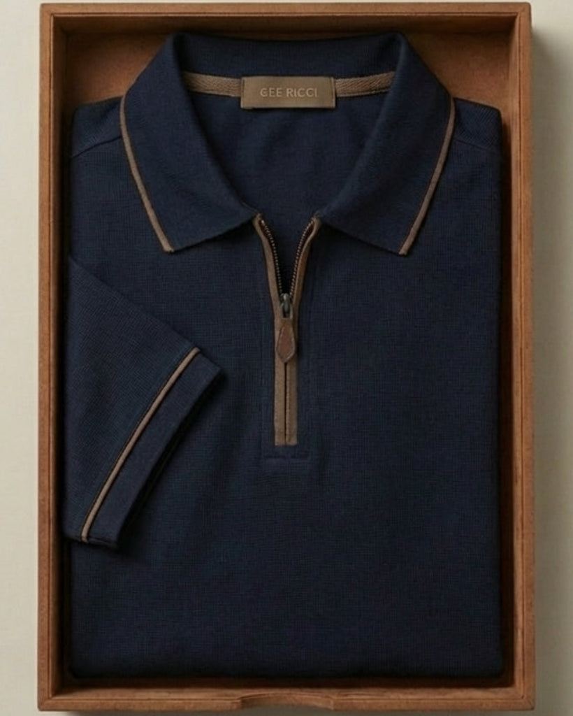 Navy polo shirt with brown trim in a wooden box on a beige background