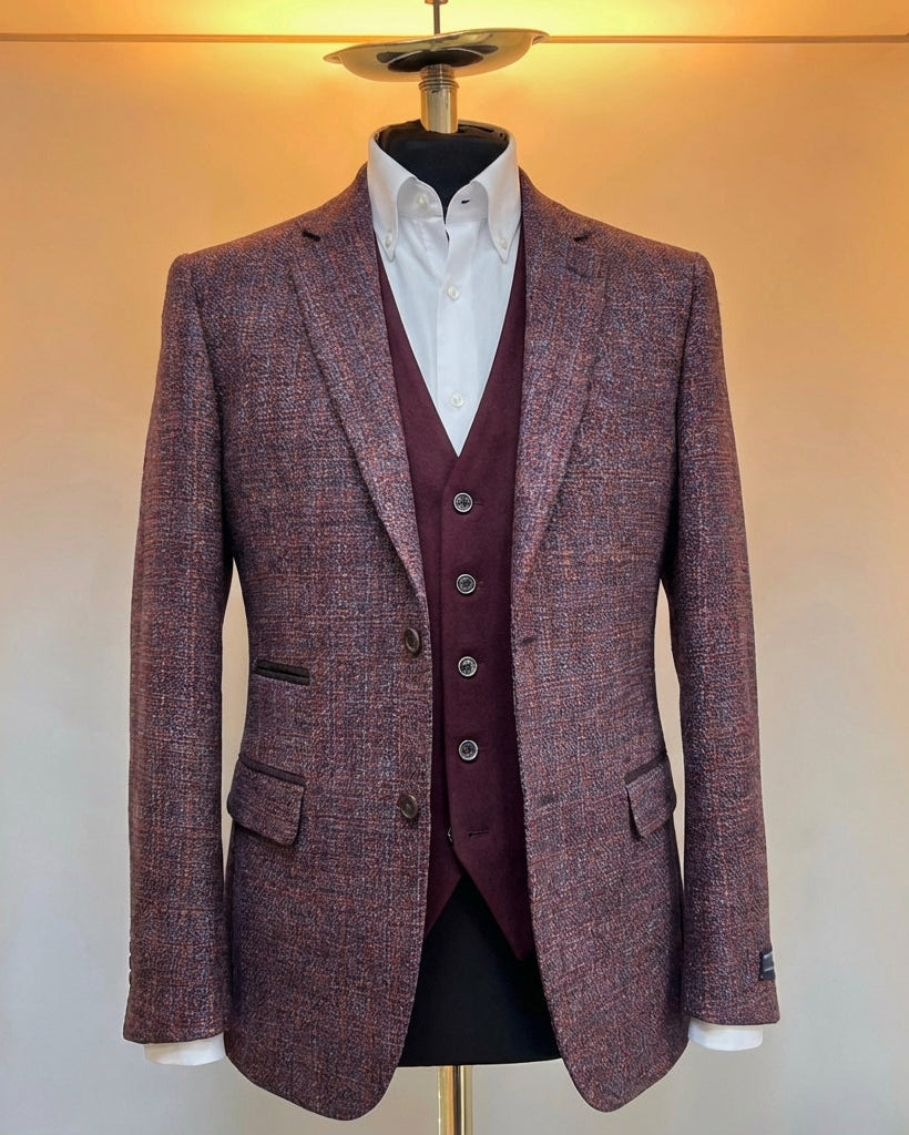 Three-piece suit with a jacket, waistcoat, and trousers on a mannequin against a neutral background.
