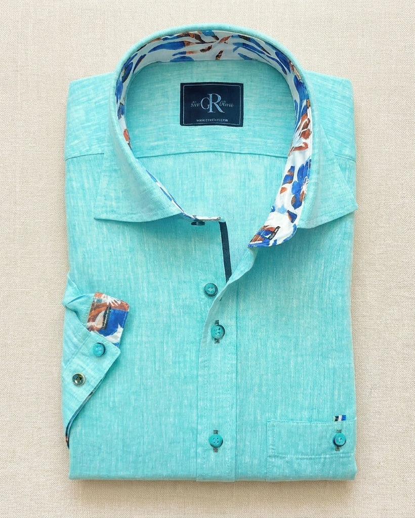 Turquoise shirt with floral collar and cuffs on a beige background