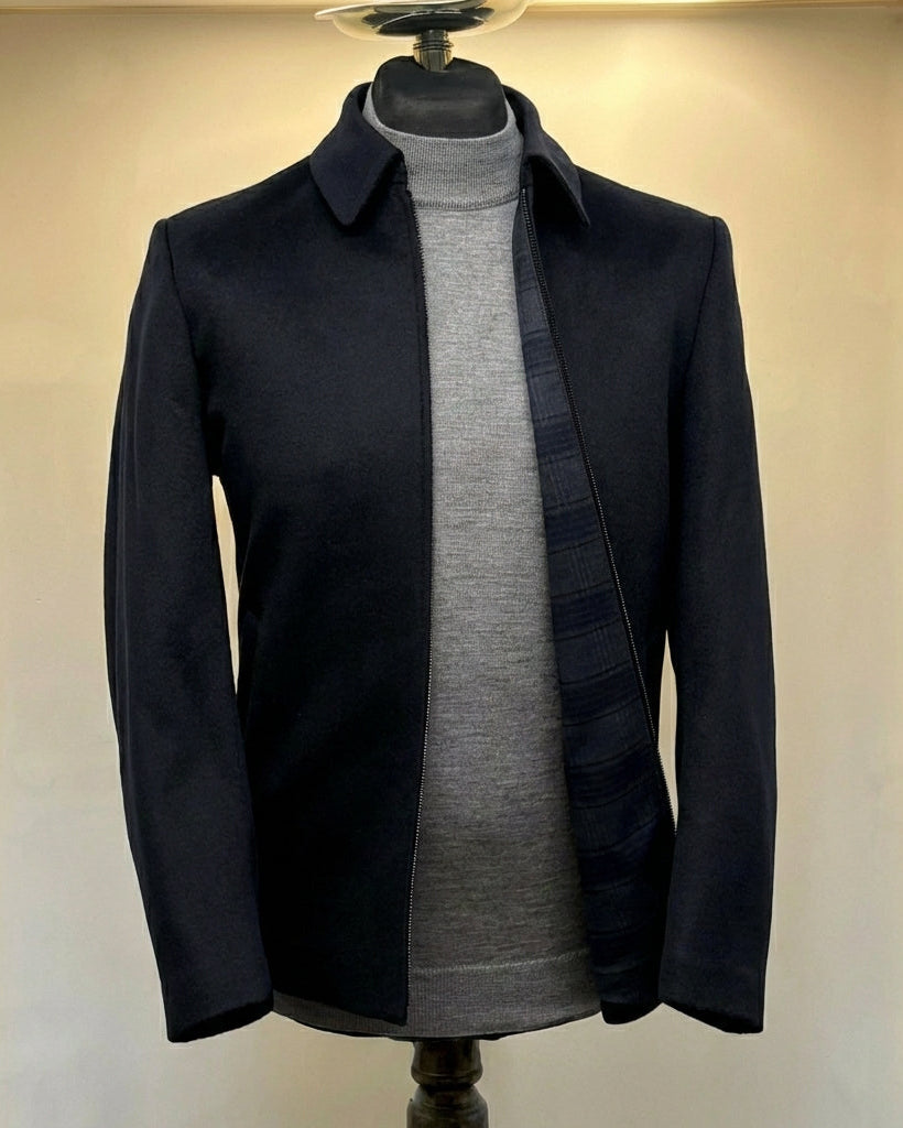 Dark coat over a gray sweater on a mannequin against a beige background