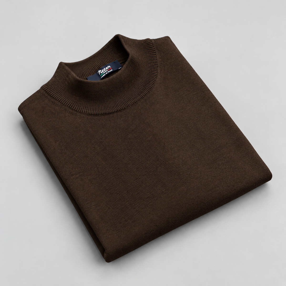 Dark brown merino wool mock neck folded on a pale grey background