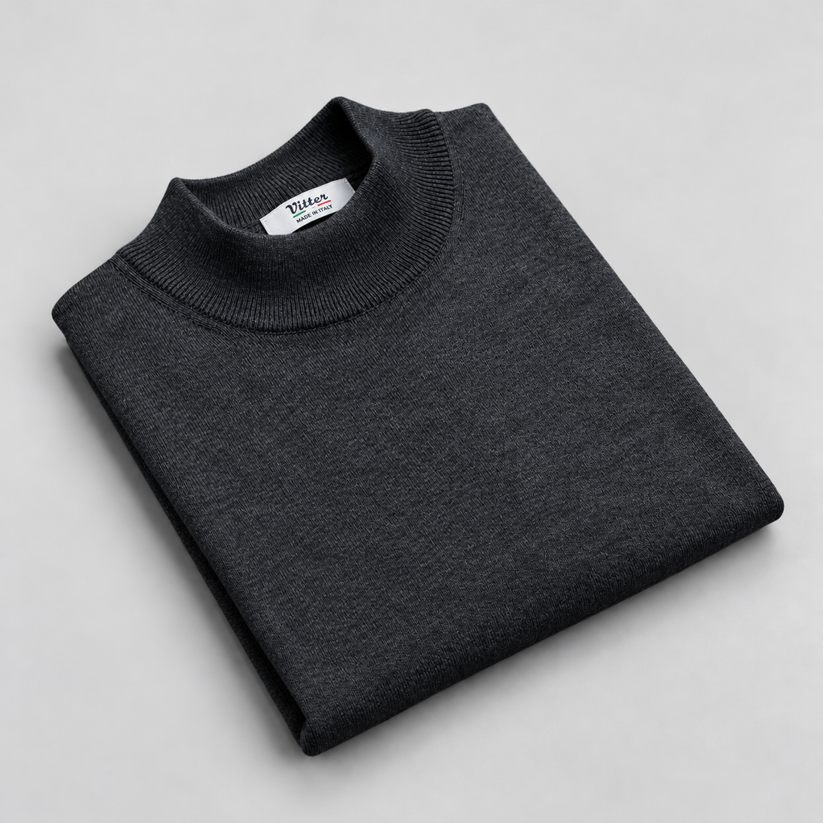 grey merino wool mock neck folded on a pale grey background